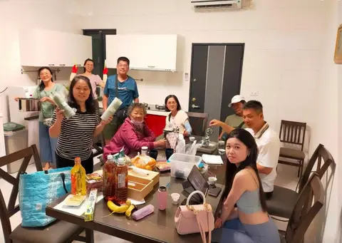 廚房裡三代一家圍著餐桌張羅食物